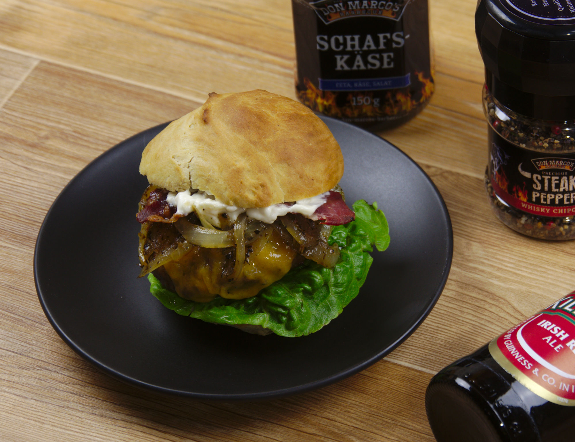 St Patricks Day Main Irish Cheddar Burger mit WonderGreen Schmorzwiebeln auf schwarzem Teller