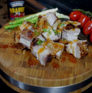 crispy asia schweinebauch auf holzplatte