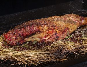 Ostern lammkeule 1 lammkeule im Smoker auf einem Bett aus Heu und Kaffeebohnen