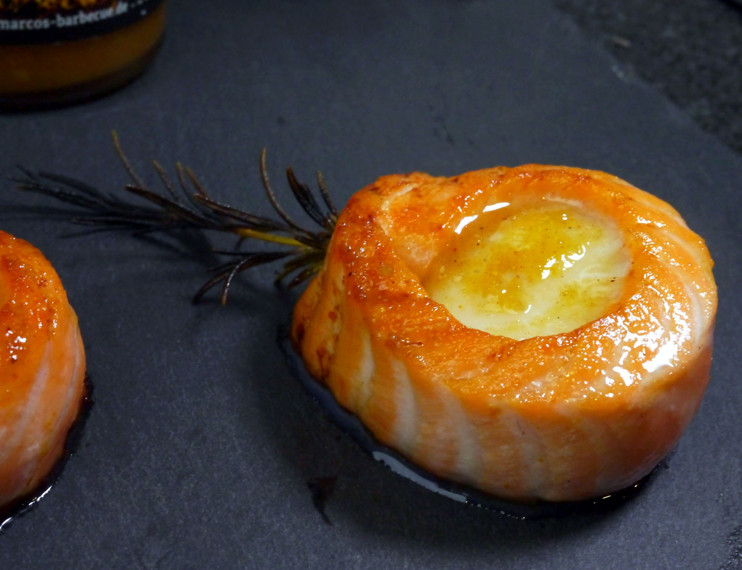 lachs main Jakobsmuschel Lachswrap auf schwarzer Granitplatte mit Rosmarinzweig