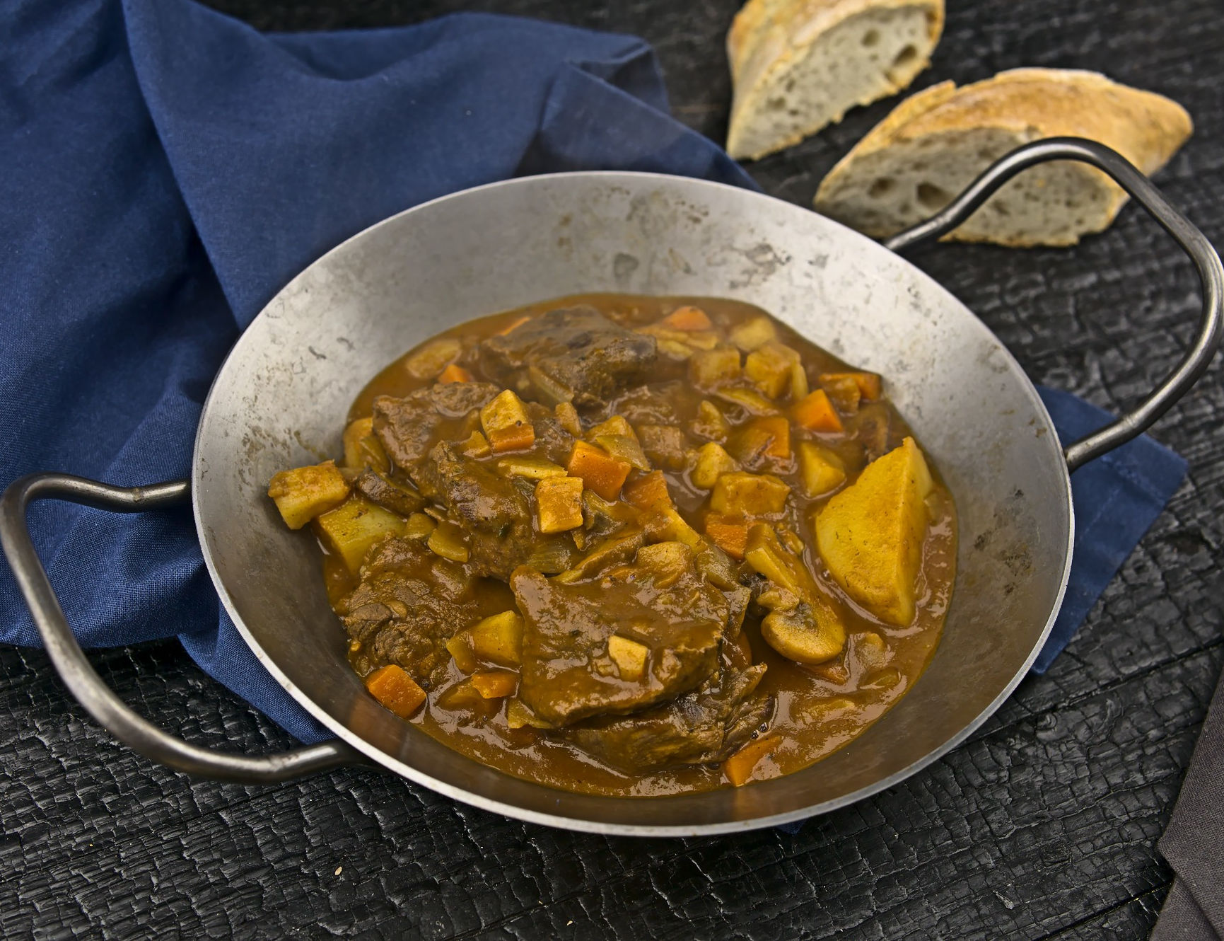 beef stew main Rindereintopf mit Baguettebrot im Hintergrund